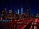 A breathtaking night view featuring the New York City skyline and iconic Brooklyn Bridge illuminated in vibrant colors.