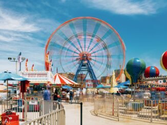 Vibrant scene of Ferris wheel and attractions at Coney Island, New York.
