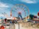 Vibrant scene of Ferris wheel and attractions at Coney Island, New York.