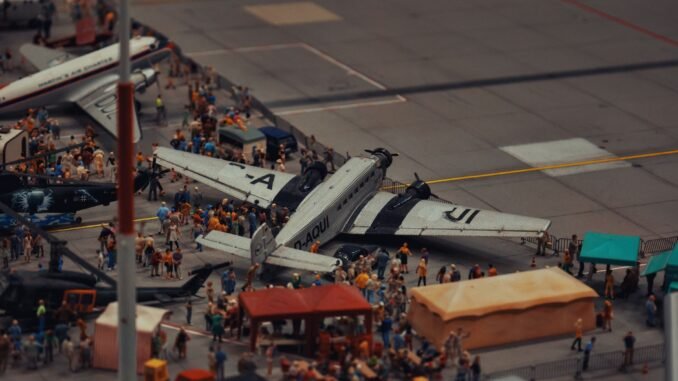A detailed miniature scene of airplanes and people at a crowded airport display.