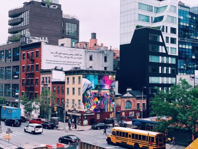 Colorful cityscape of New York with urban murals, modern architecture, and bustling street life.