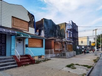 Boarded-up houses showing decay in Queens, New York.